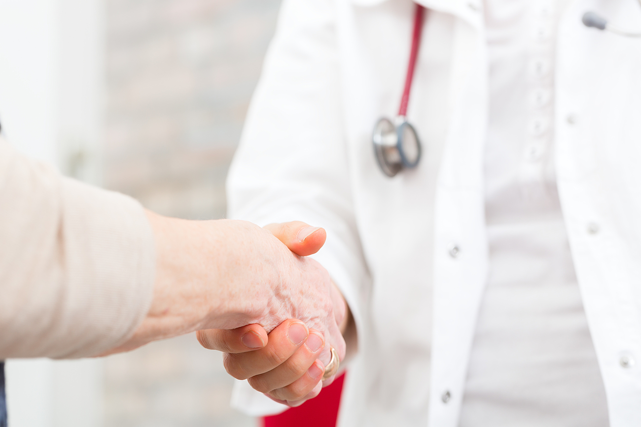 Ihre Gesundheit in besten Händen Arzt gibt Patient die Hand