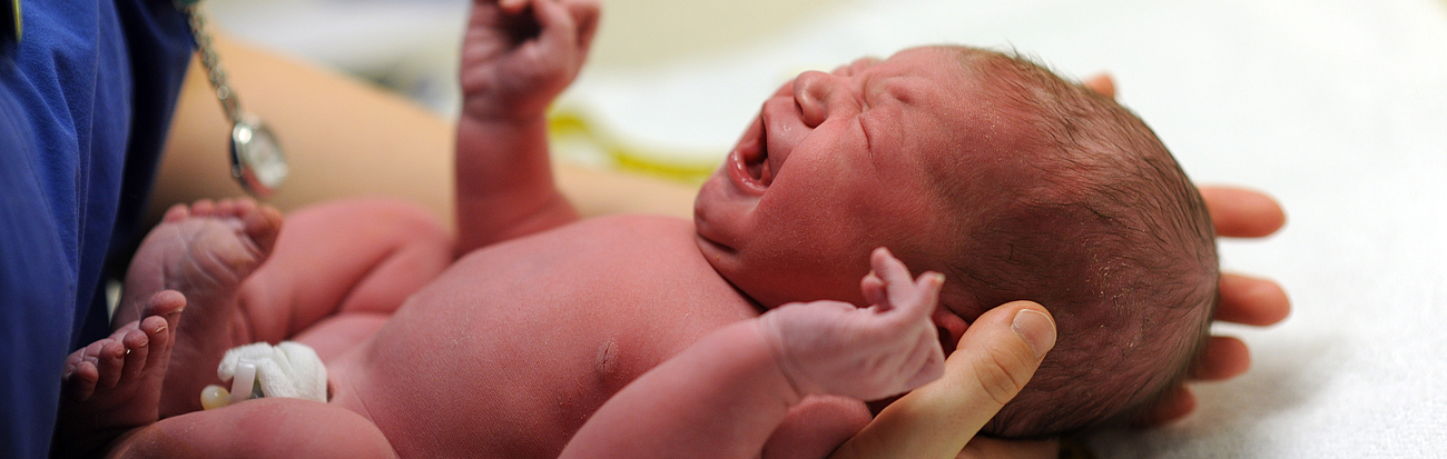 Baby direkt nach der Geburt Säugling in den Händen einer medizinischen Fachkraft
