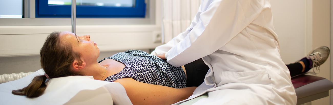 Patientin bei Untersuchung des Bauchs Ärztin tastest einer Patienten den Bauch ab