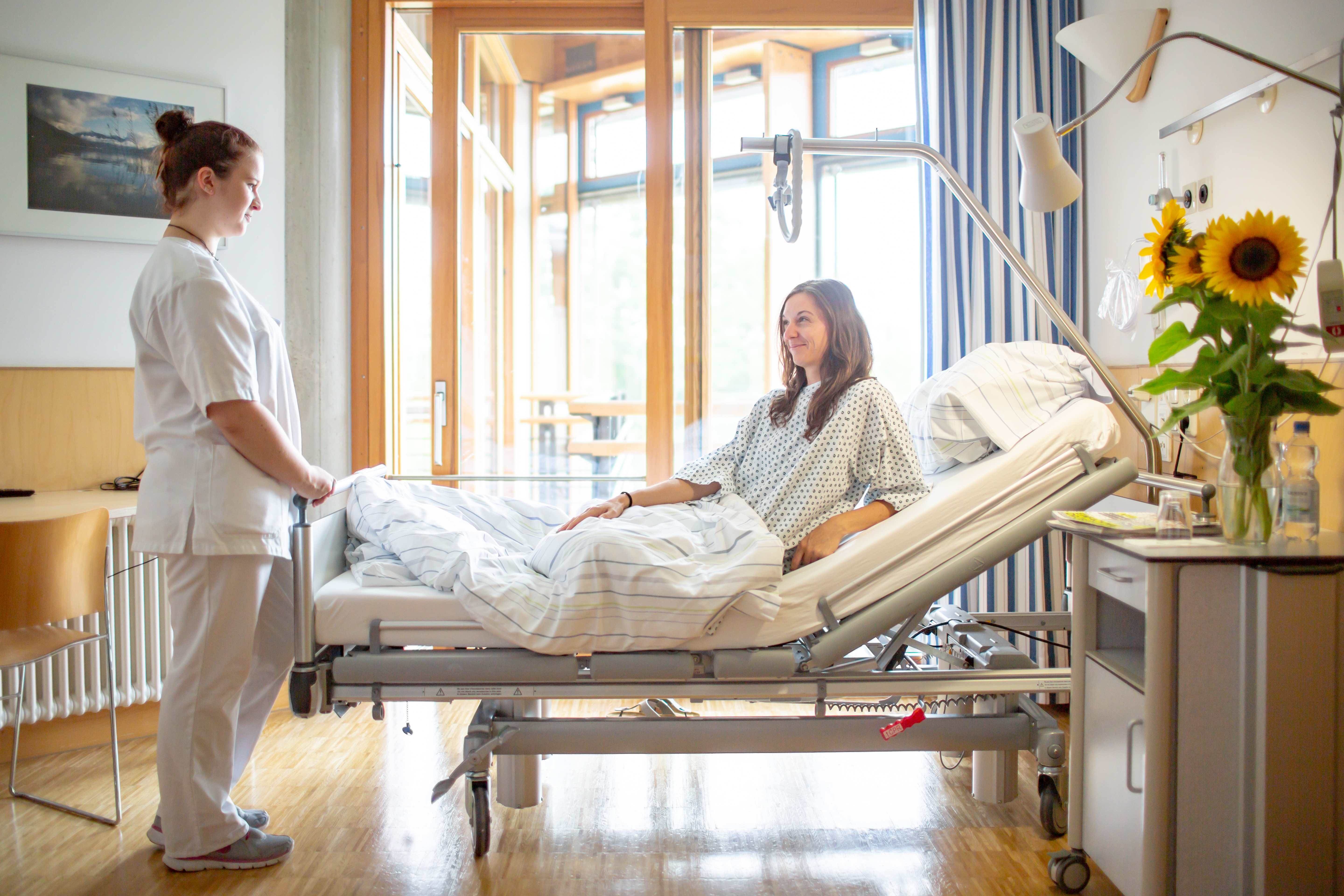 Schwester spricht mit Patientin im Zimmer Schwester spricht mit Patientin im Zimmer