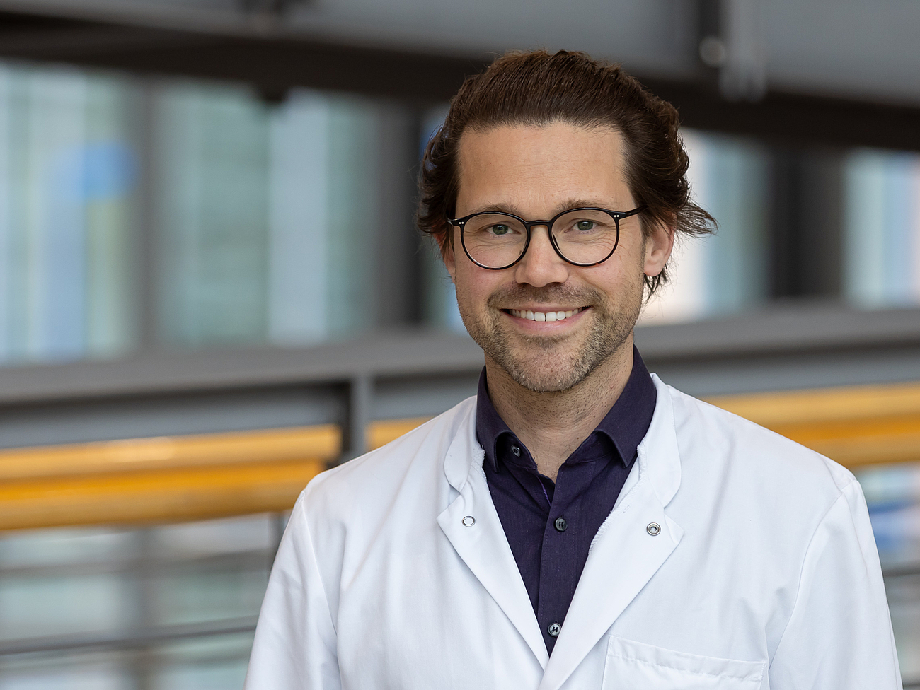 Dr. Busch Arzt lächelt in die Kamera.