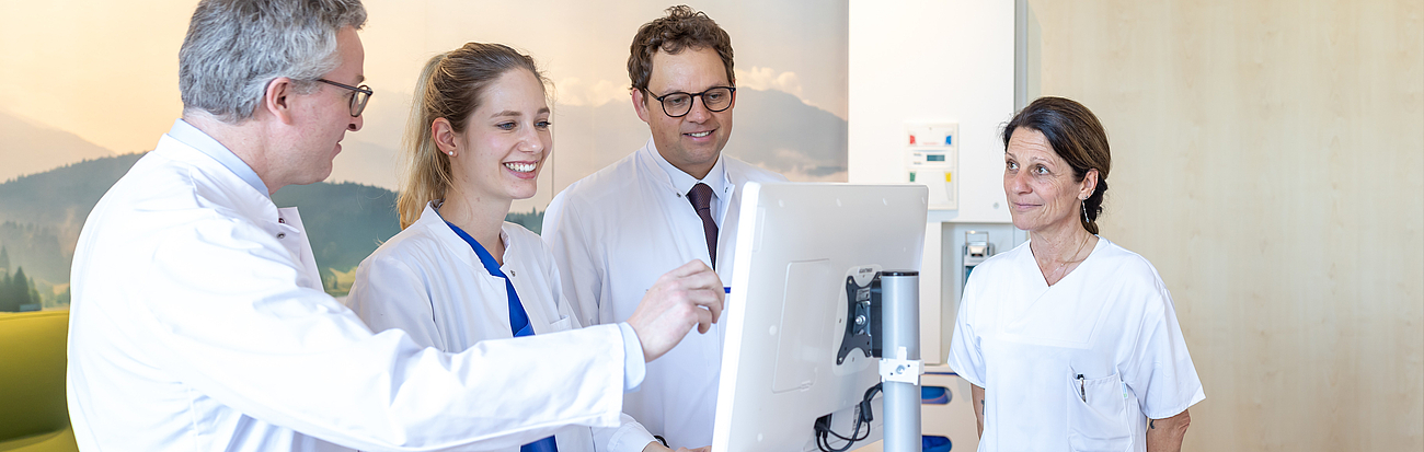 Ärzte im Gespräch Ärzte unterhalten sich vor einem Computer im Stehen miteinander.