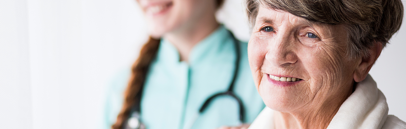 Pflegerin mit zufriedener Patientin