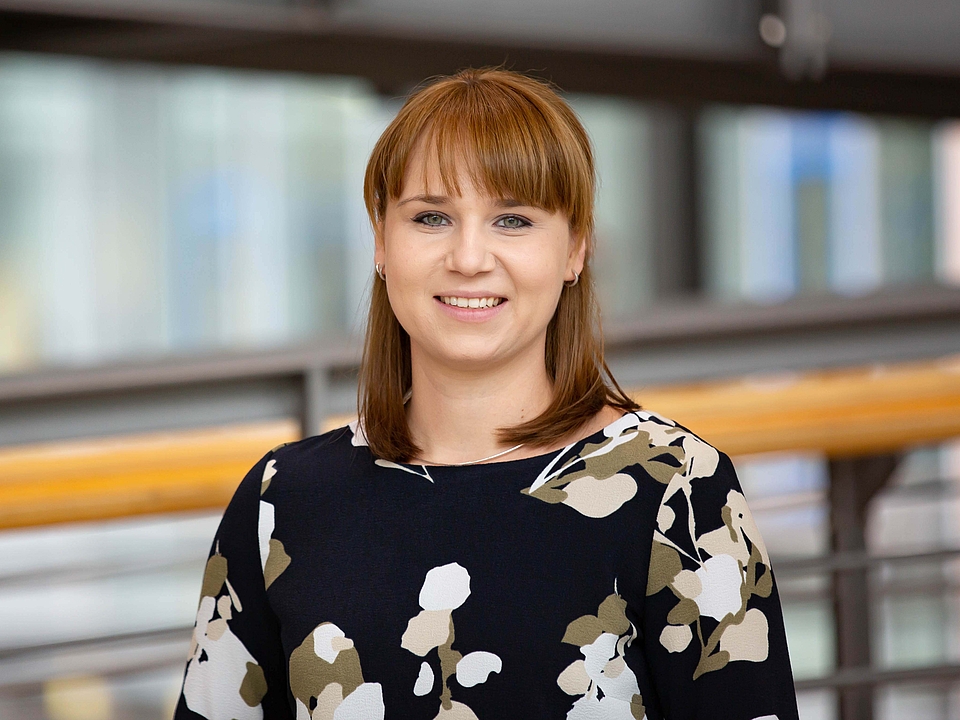 Mitarbeiterin lächelt in die Kamera.