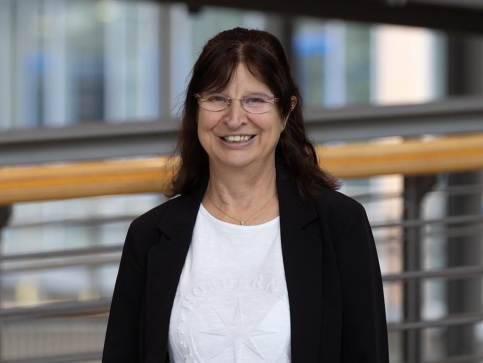 Mitarbeiterin lächelt in die Kamera.