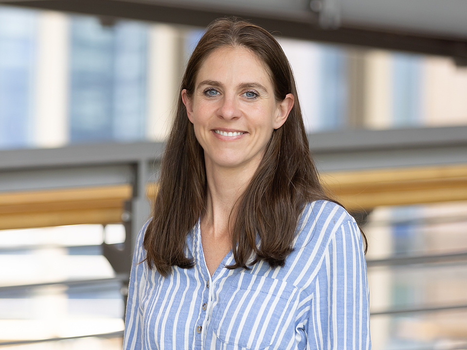 Mitarbeiterin lächelt in die Kamera.