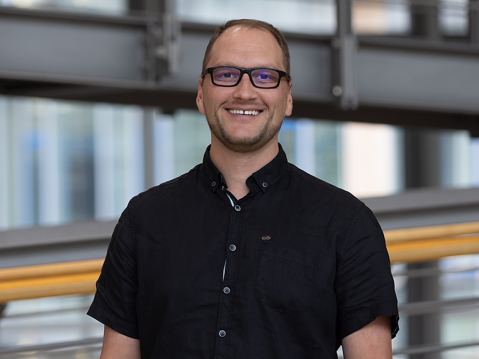 Mitarbeiter lächelt in die Kamera.