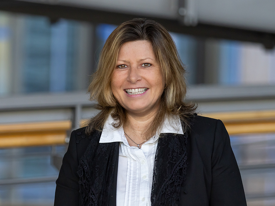 Mitarbeiterin lächelt in die Kamera.