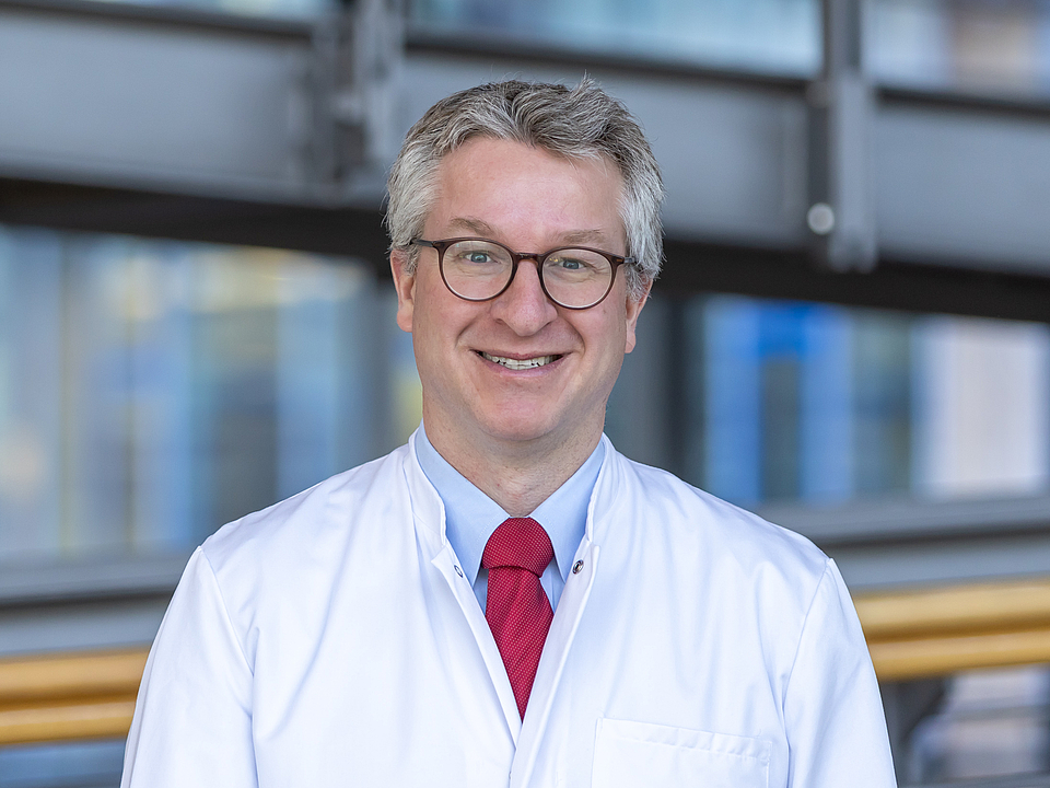 Arzt lächelt in die Kamera.