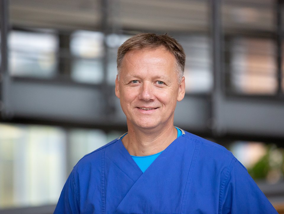 Pfleger lächelt in die Kamera.