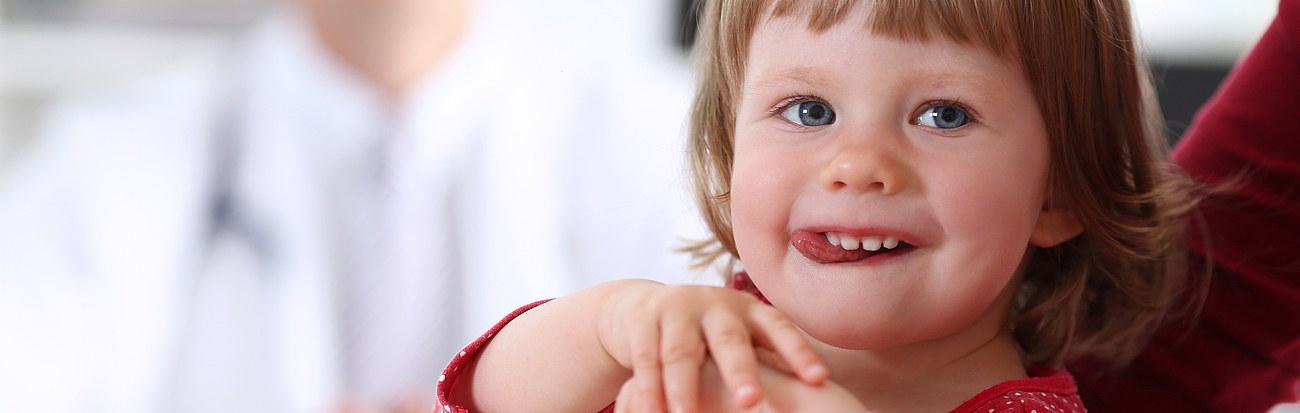 Kind mit Ärztin im Hintergrund