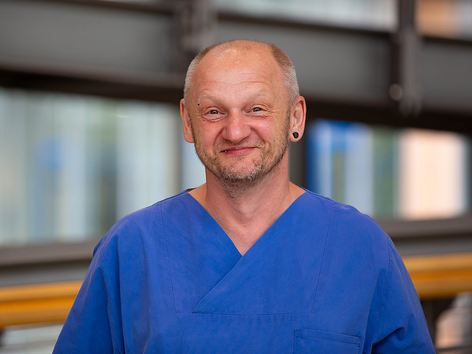 Pfleger lächelt in die Kamera.