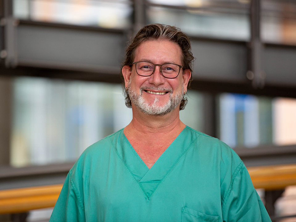 Pfleger lächelt in die Kamera.