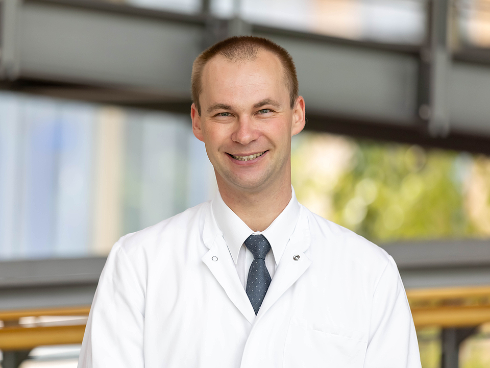 Arzt lächelt in die Kamera.