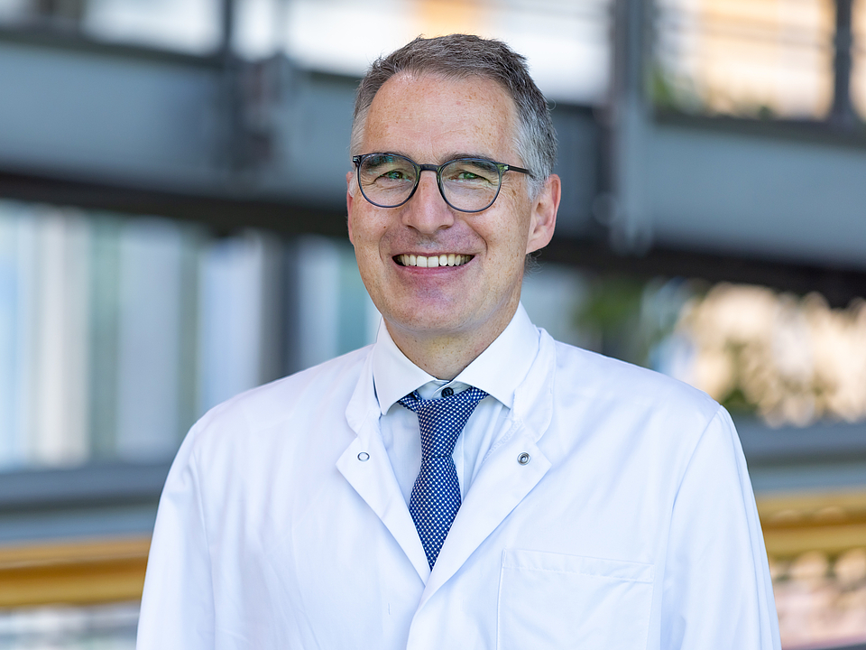 Arzt lächelt in die Kamera.