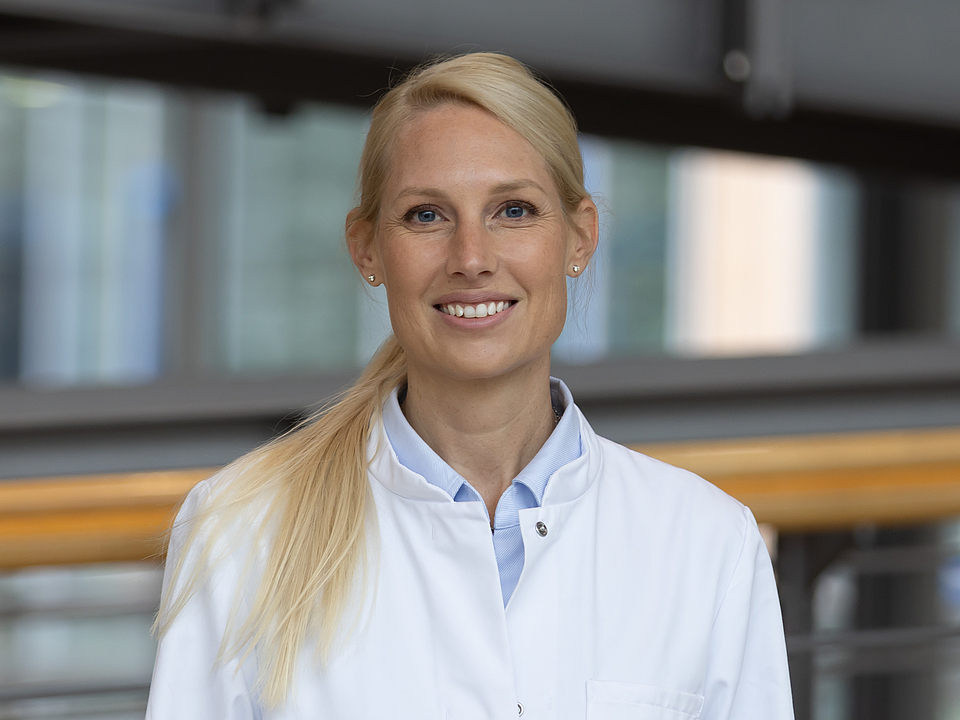 Ärztin lächelt in die Kamera.