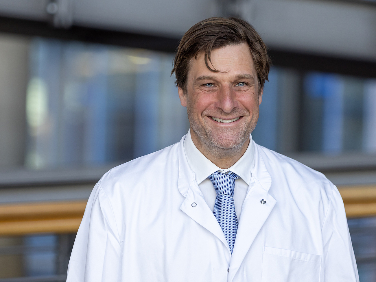 Arzt lächelt in die Kamera.