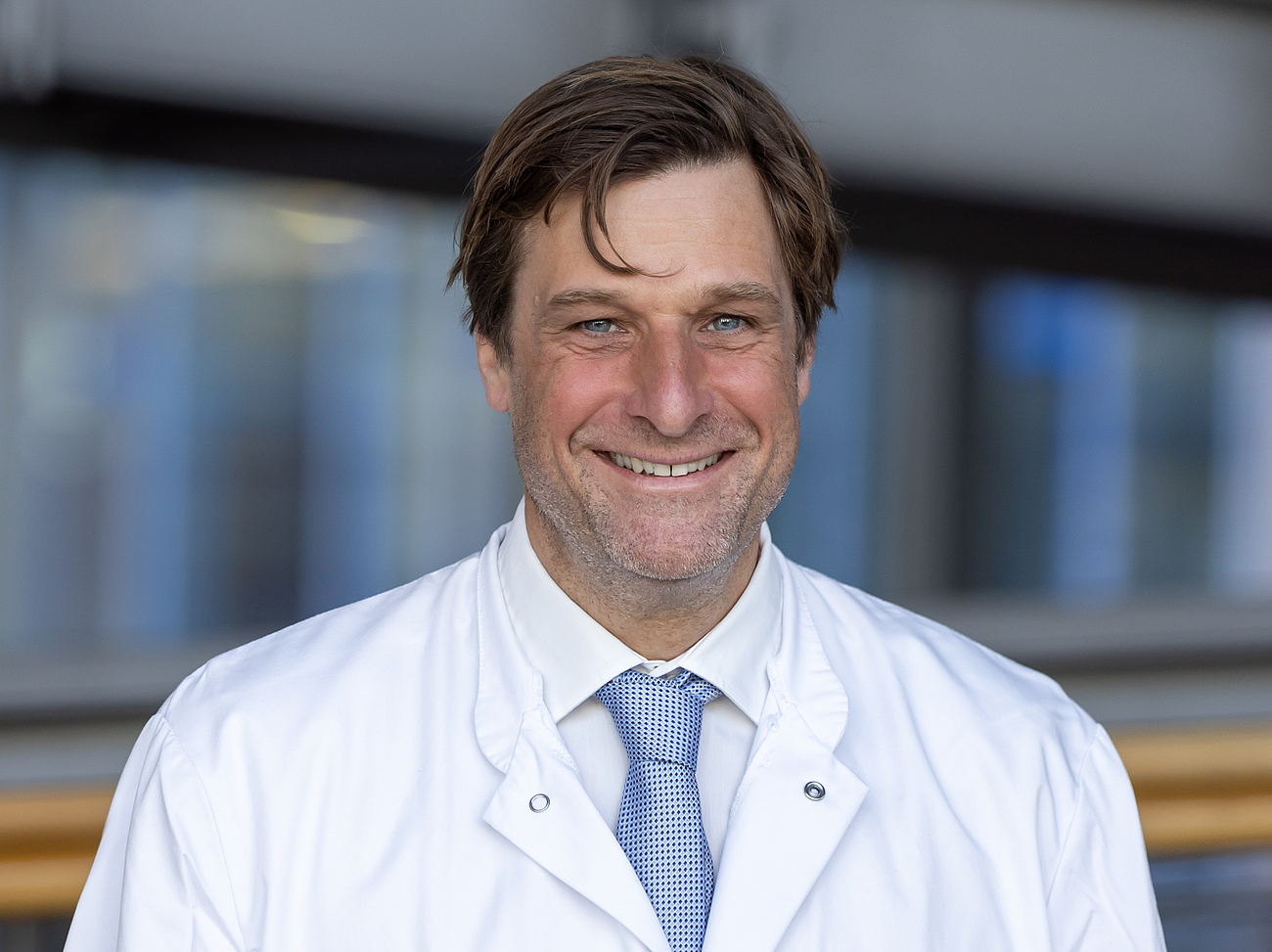 Arzt lächelt in die Kamera.