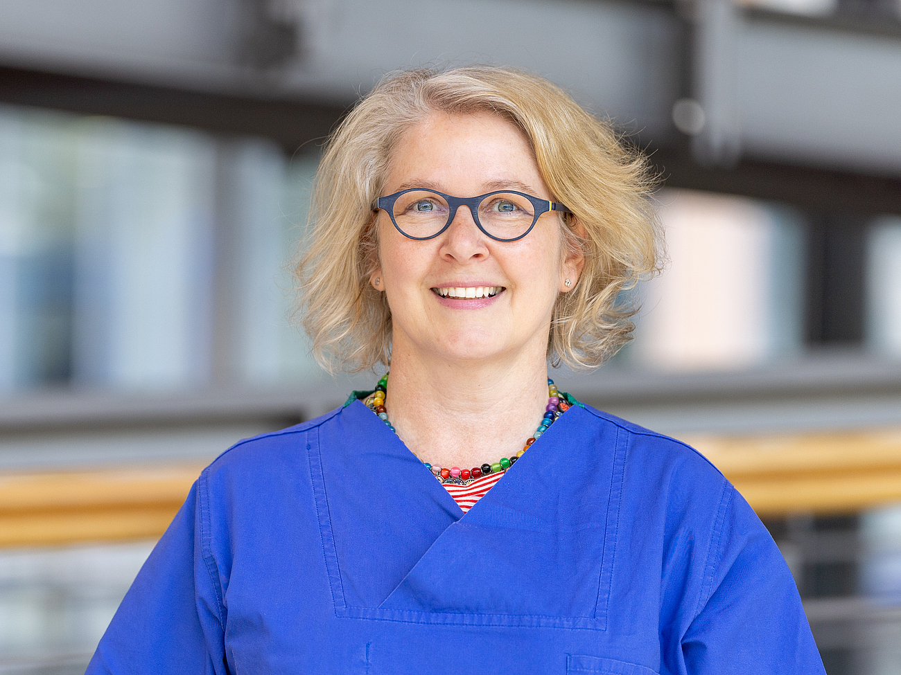 Pflegerin lächelt in die Kamera.