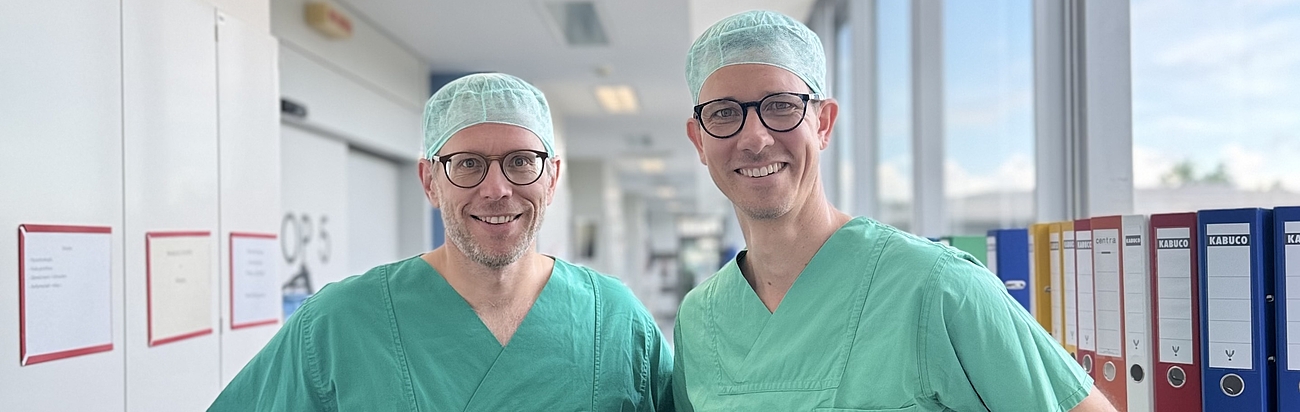 Zwei Operateure aus zwei Kliniken sind zusammen ein starkes Team für Patientinnen und Patienten mit Krebs der Leber und der Bauchspeicherdrüse – Prof. Dr. Jan D‘ Haese, Chefarzt Allgemein-, Viszeral-, Gefäß- & Endokrine Chirurgie des Krankenhaus Agatharied (links) und Dr. Alexander Gratz, Chefarzt der Allgemeinen und Speziellen Viszeralchirurgie in Ebersberg (rechts).