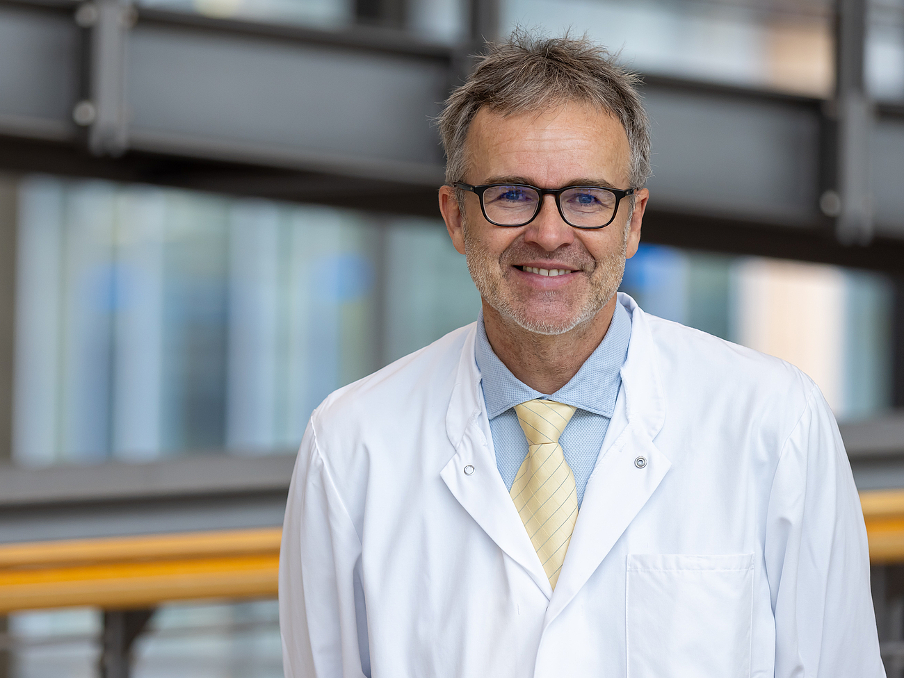 Arzt lächelt in die Kamera.