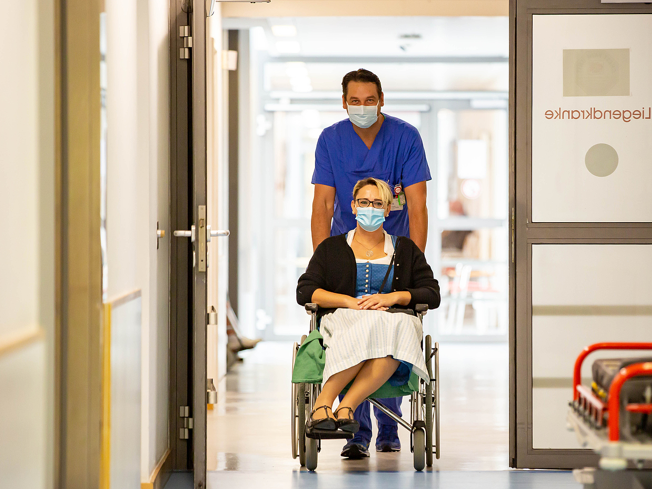 Patientin im Rollstuhl Patientin wird im Rollstuhl in die Notaufnahme gebracht