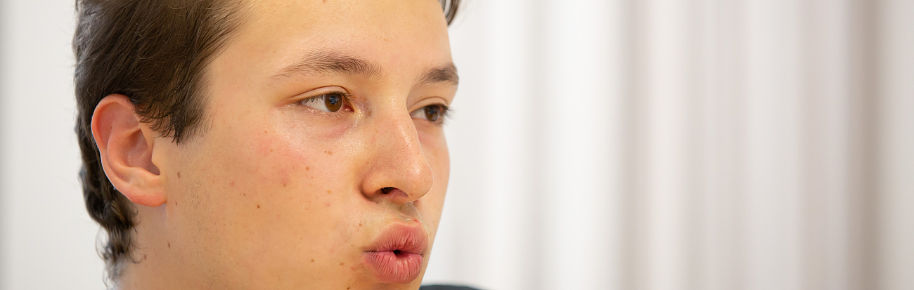 Junger Mann macht logopädische Mundübung