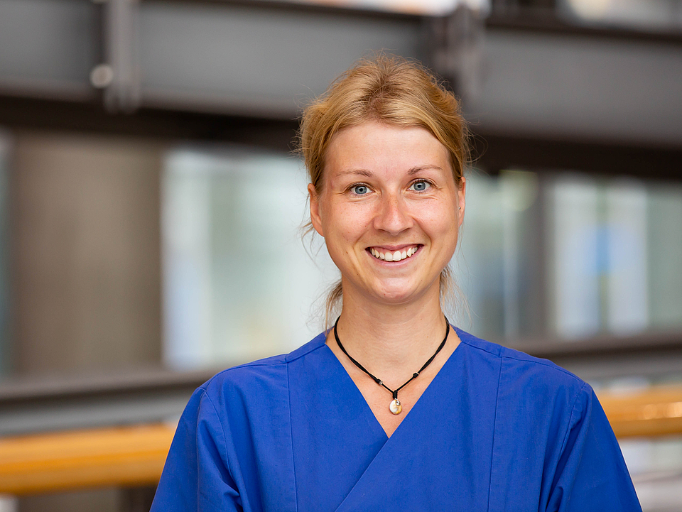 Pflegerin lächelt in die Kamera.