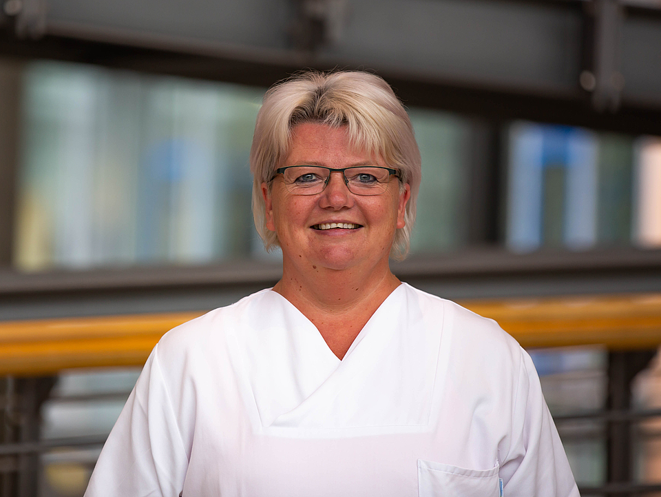 Frau Boettcher Pflegerin lächelt in die Kamera.