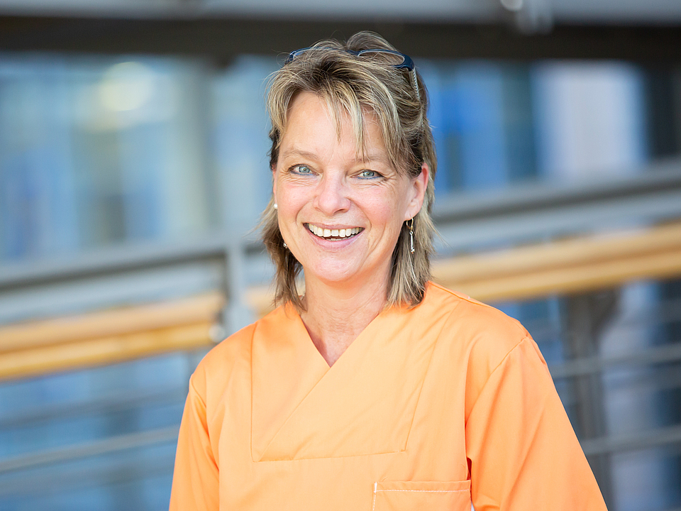 Frau Frosin Pflegerin lächelt in die Kamera.