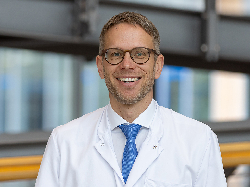 Prof. Dr. D'Haese Arzt lächelt in die Kamera.