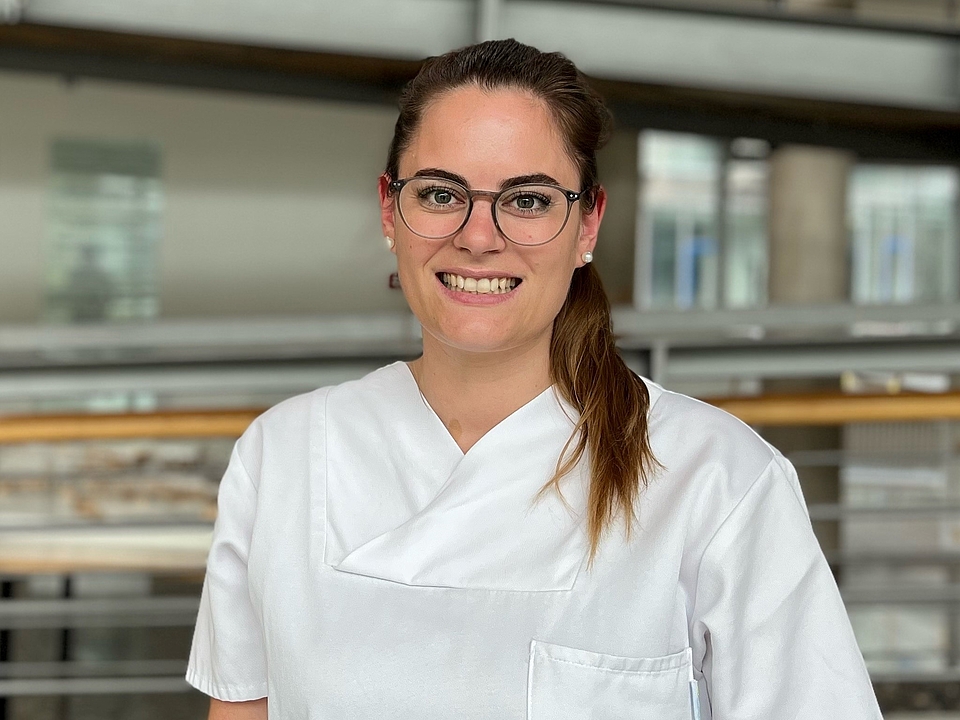 Pflegerin lächelt in die Kamera.