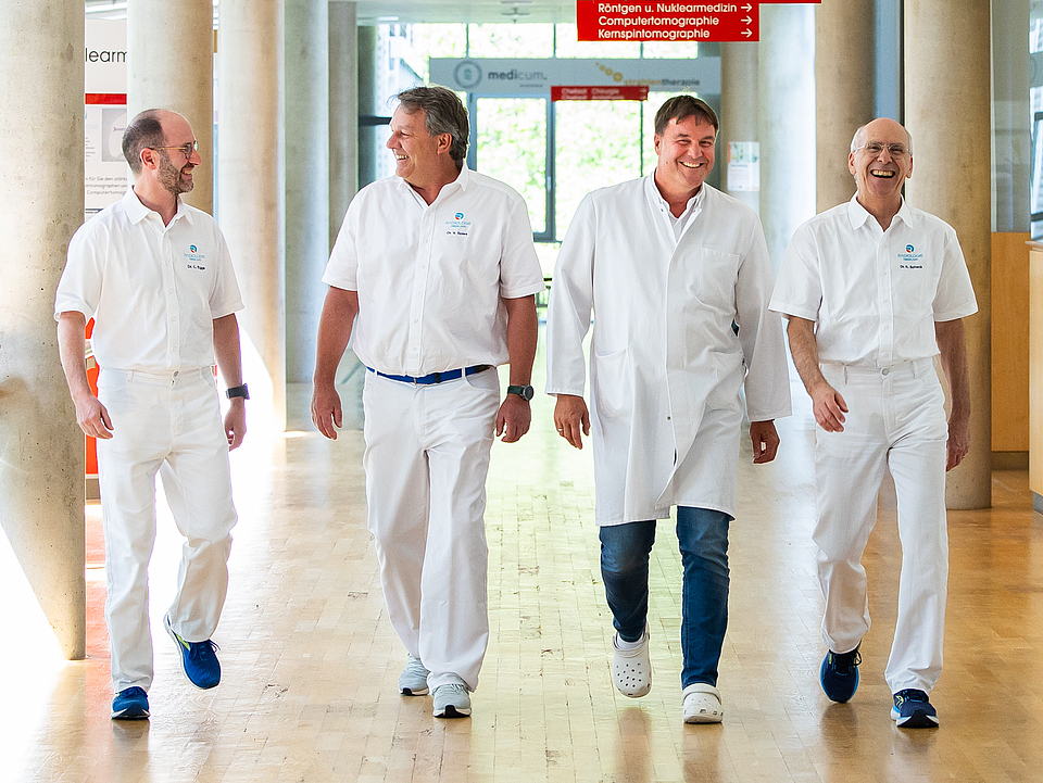 Ein Gruppenfoto von Ärzten, welche den Flur entlang laufen.