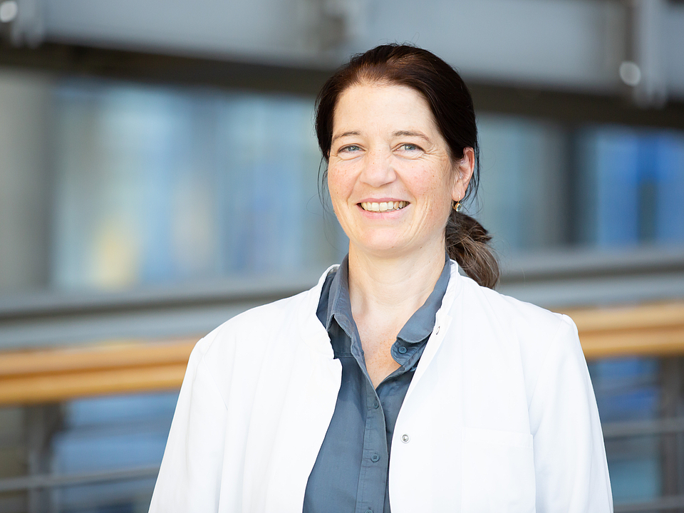 Eine Ärztin lächelt in die Kamera.