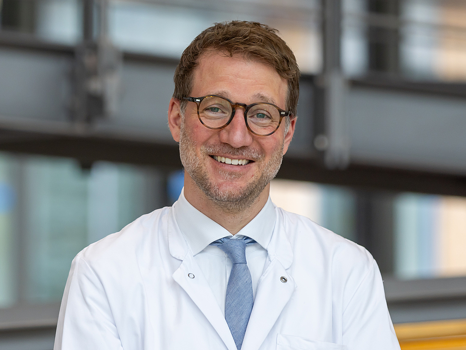 Dr. Gießen-Jung Arzt lächelt in die Kamera.