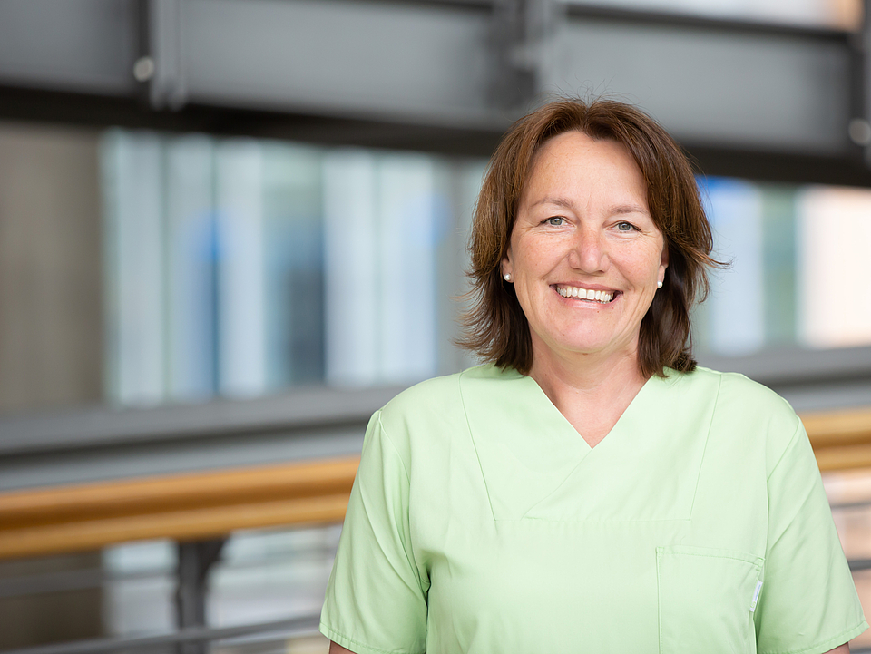 Frau Koehler Pflegerin lächelt in die Kamera.