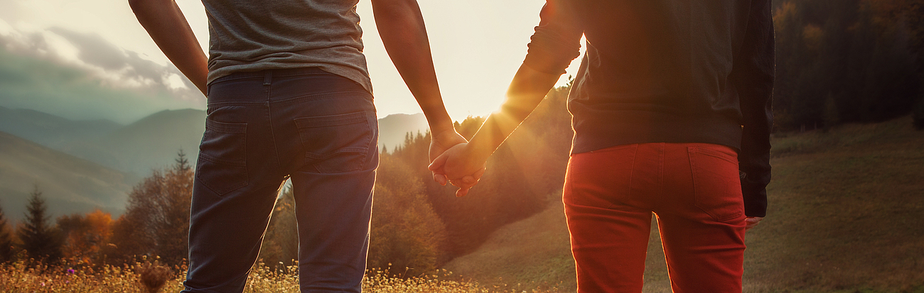Paar hält sich bei Sonnenaufgang in den Bergen die Hand