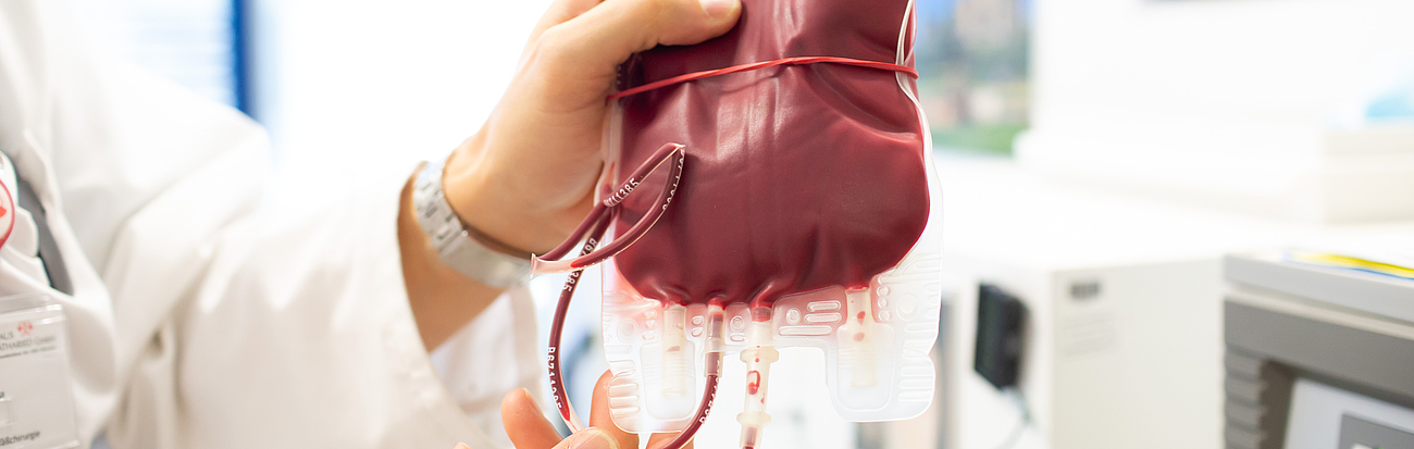 Medizinische Fachkraft hält eine Blutkonserve in der Hand