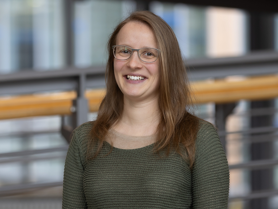 Mitarbeiterin lächelt in die Kamera.