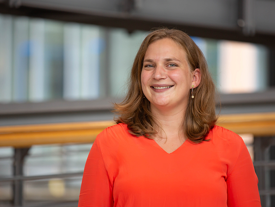 Mitarbeiterin lächelt in die Kamera.