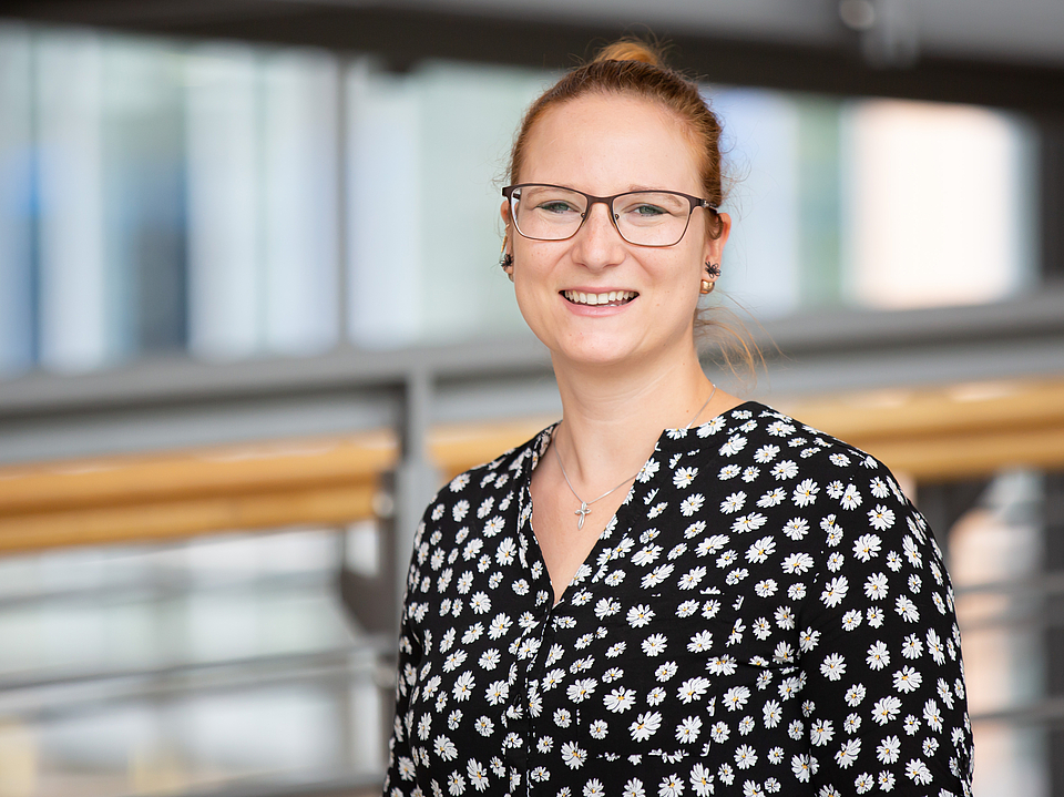 Mitarbeiterin lächelt in die Kamera.