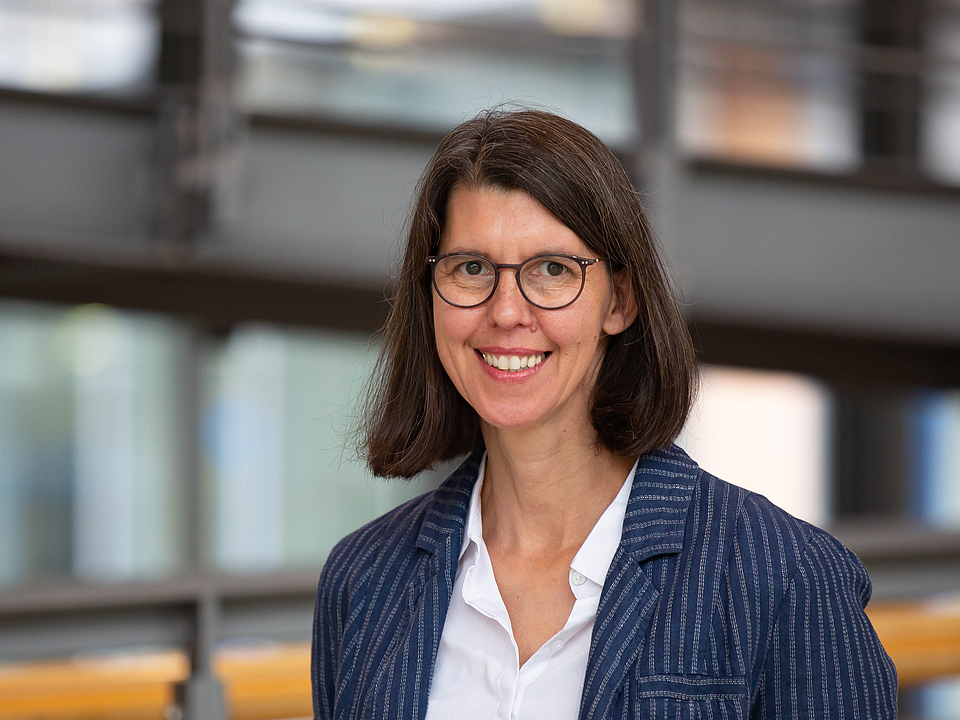 Mitarbeiterin lächelt in die Kamera.