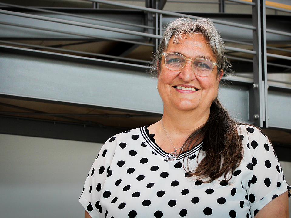 Mitarbeiterin lächelt in die Kamera.