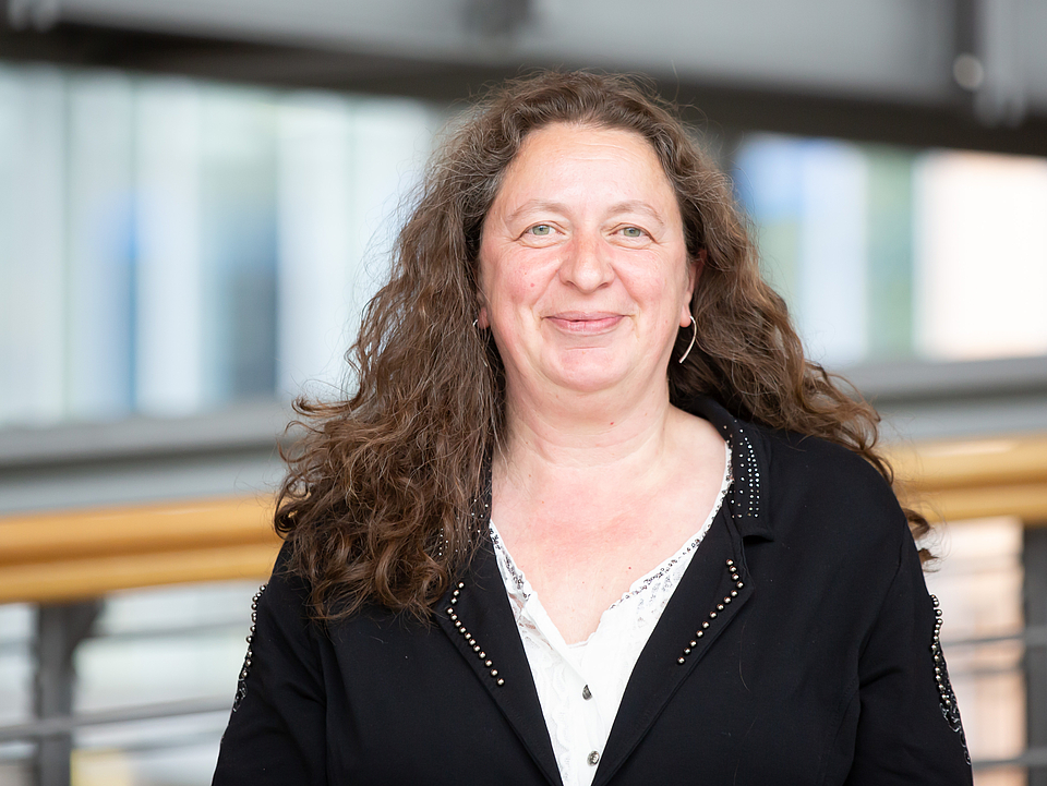 Mitarbeiterin lächelt in die Kamera.