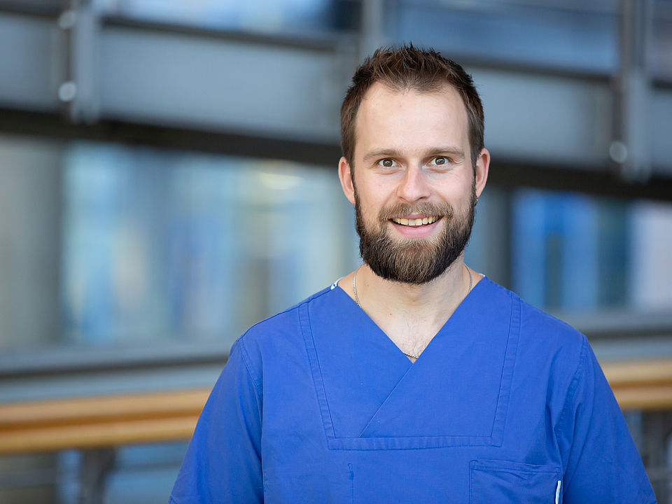 Pfleger lächelt in die Kamera.