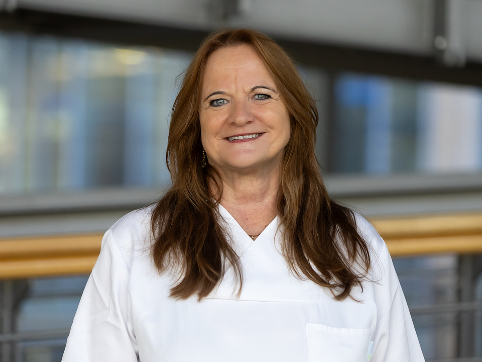 Eine Pflegekraft lächelt in die Kamera.