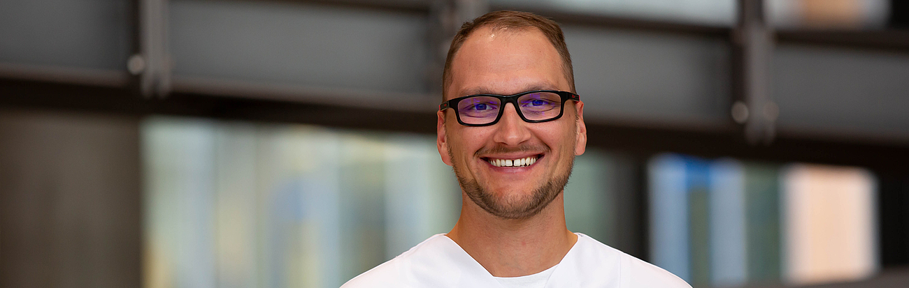 Pfleger lächelt in die Kamera.