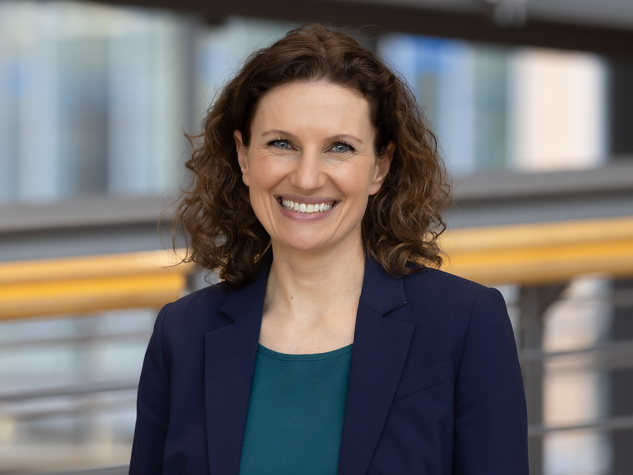 Mitarbeiterin lächelt in die Kamera.