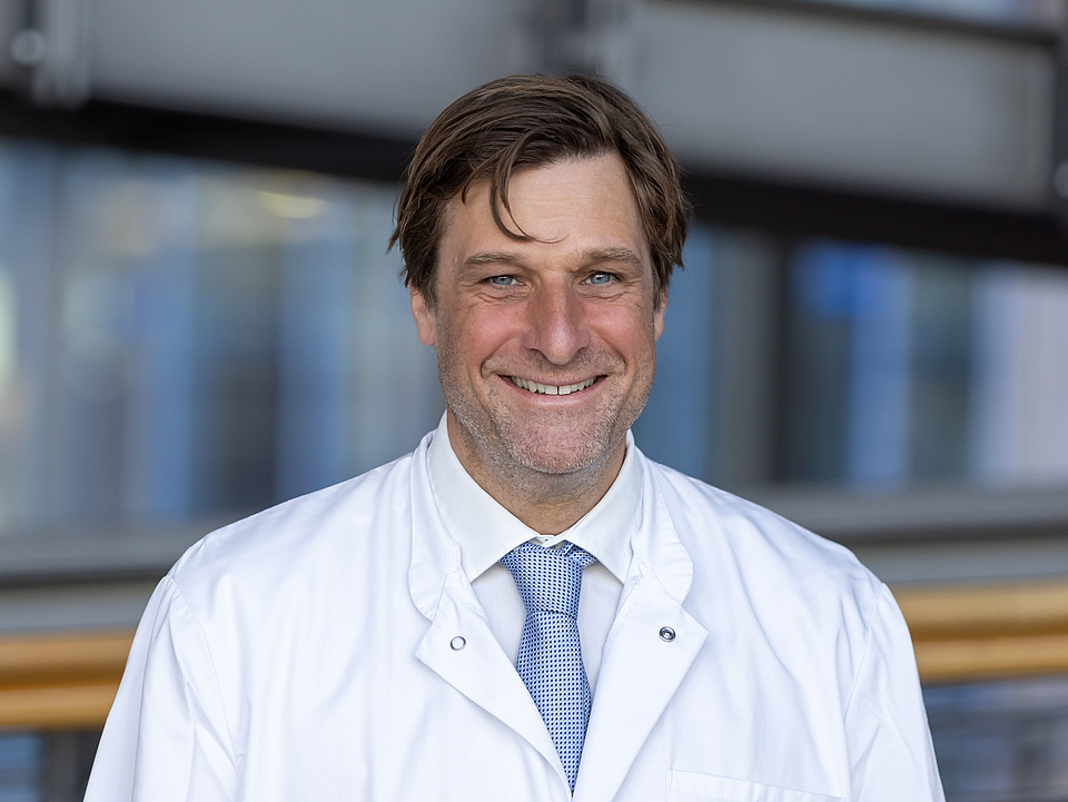 Dr. Gumpinger Arzt lächelt in die Kamera.