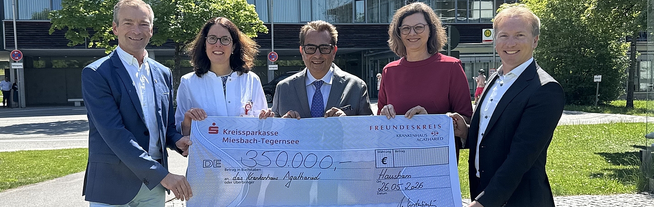 Gruppenfoto einer Scheckübergabe vor dem Krankenhaus Agatharied.